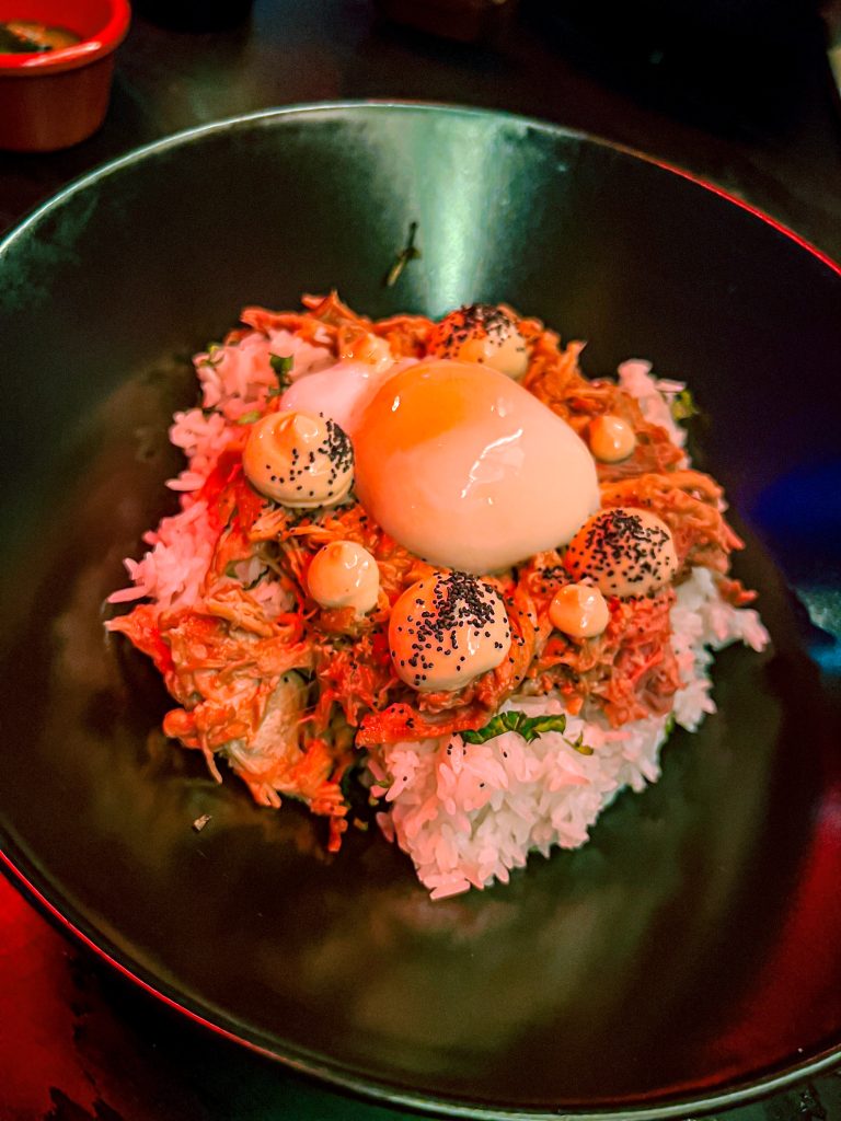 Rice dish with egg on top on a black plate