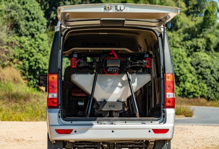 A high-tech agricultural drone securely stored in the back of a van, ready for deployment.