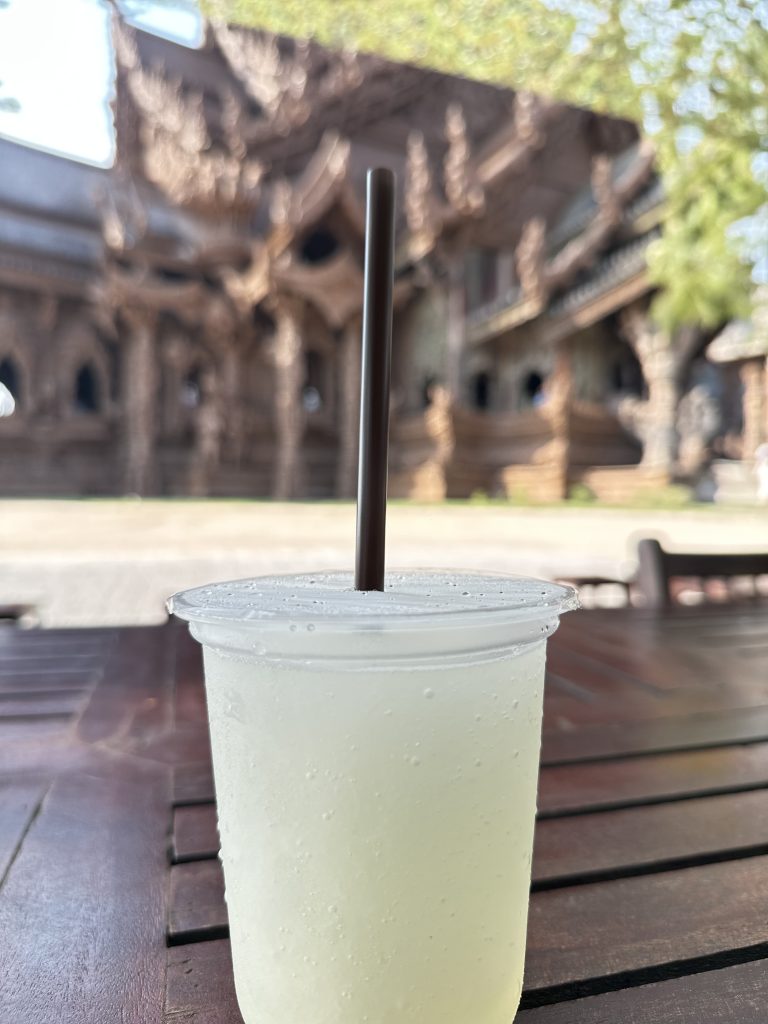 Smoothie 
A plastic cup filled with smoothie beverage and a straw is placed on a wooden table.