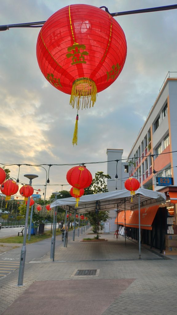 A vibrant display of red Chinese lanterns hanging along a street, symbolizing prosperity and good fortune, creating a festive atmosphere against the evening sky.
