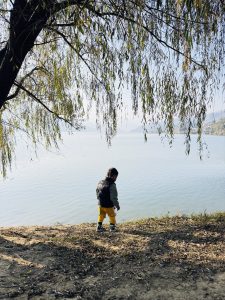 A young child walking along the edge of Fewa Lake in Pokhara, Nepal
