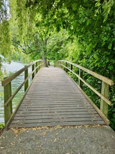 A wooden bridge surrounded by lush greenery in Kilchberg Municipality, Zurich. 