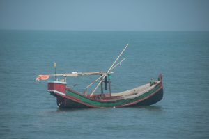 A wooden fishing boat floating on the sea. 
