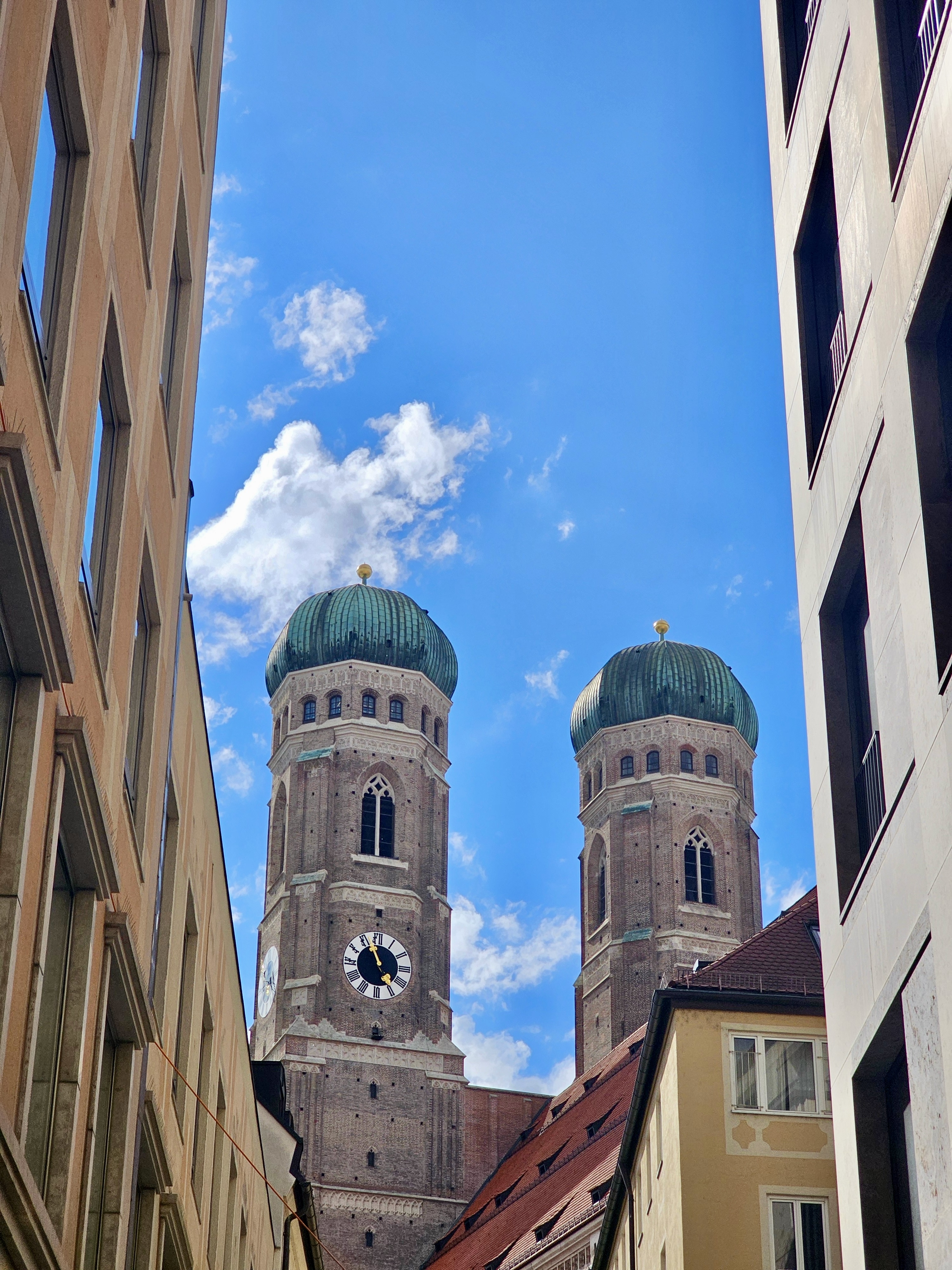 Framed view of the iconic Frauenkirche towers against a bright blue sky in Munich