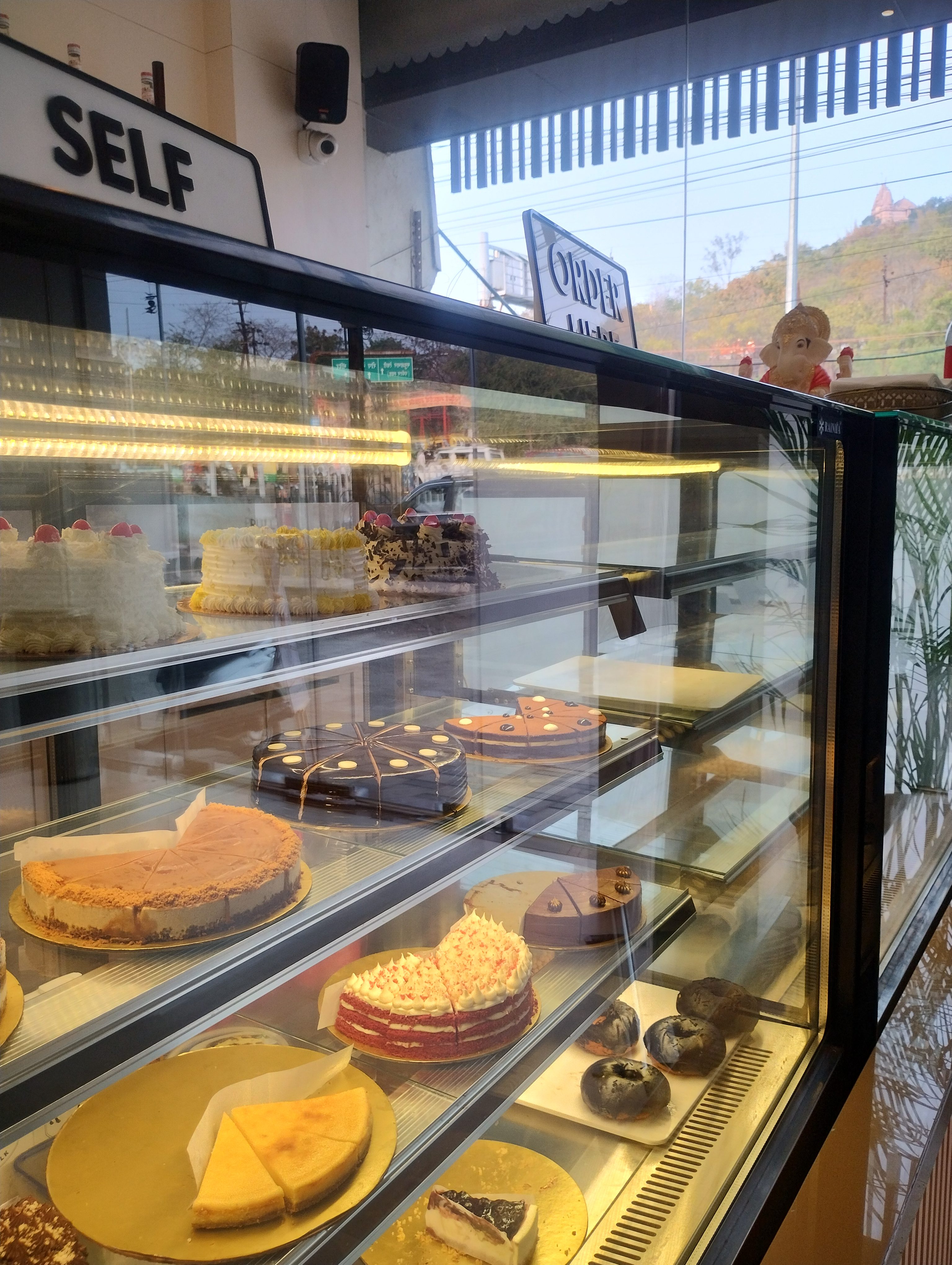 A delightful bakery display filled with an array of tempting cakes, pastries, and donuts, ready to satisfy any sweet craving.