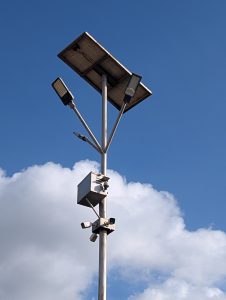 Camera stand in midair with lights and showing blue sky with clouds