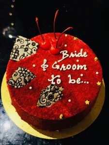 A red velvet cake with 'bride and groom to be' written on it. 
