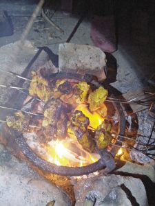Meat on skewers over a flaming brazier.