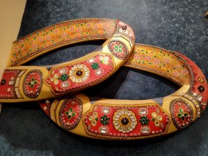 

Two ornate, colorful stone yokes are adorned with intricate floral and geometric patterns.