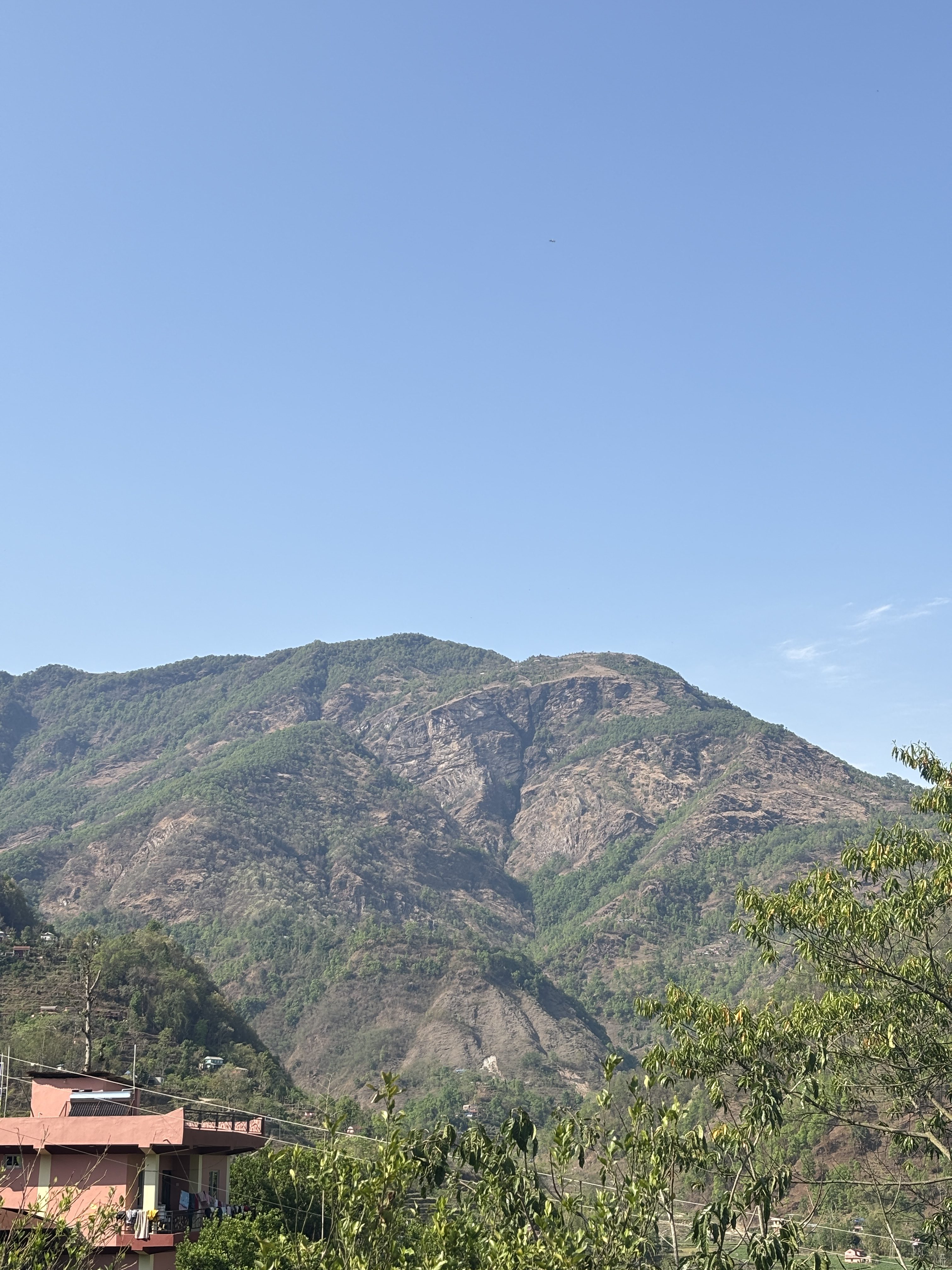 A landscape view of a mountain range under a clear blue sky.
