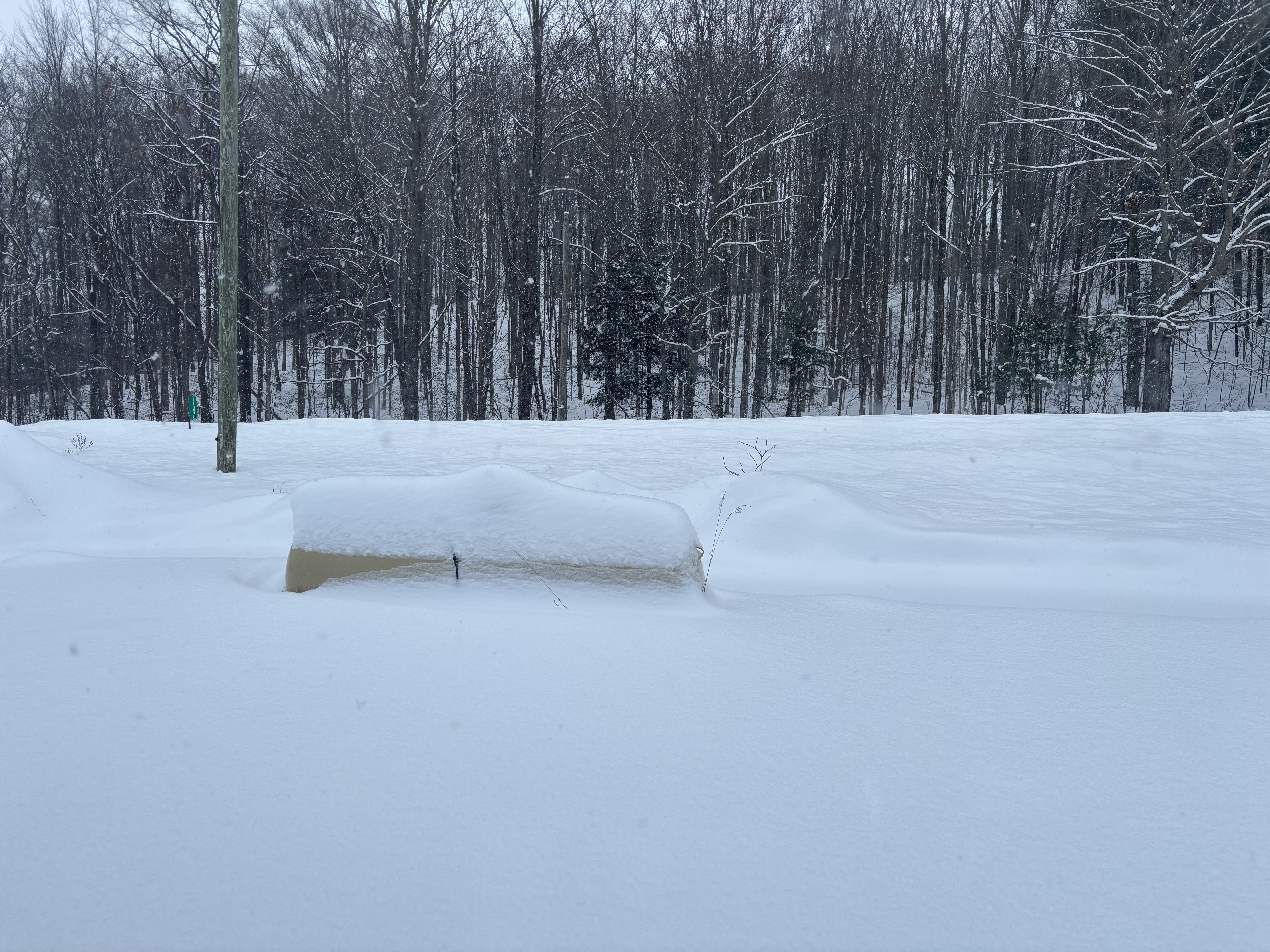 A large fuel tank, commonly called a pig, half buried in snow.