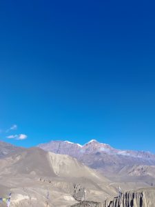 A landscape showcasing rugged mountains under a clear blue sky.