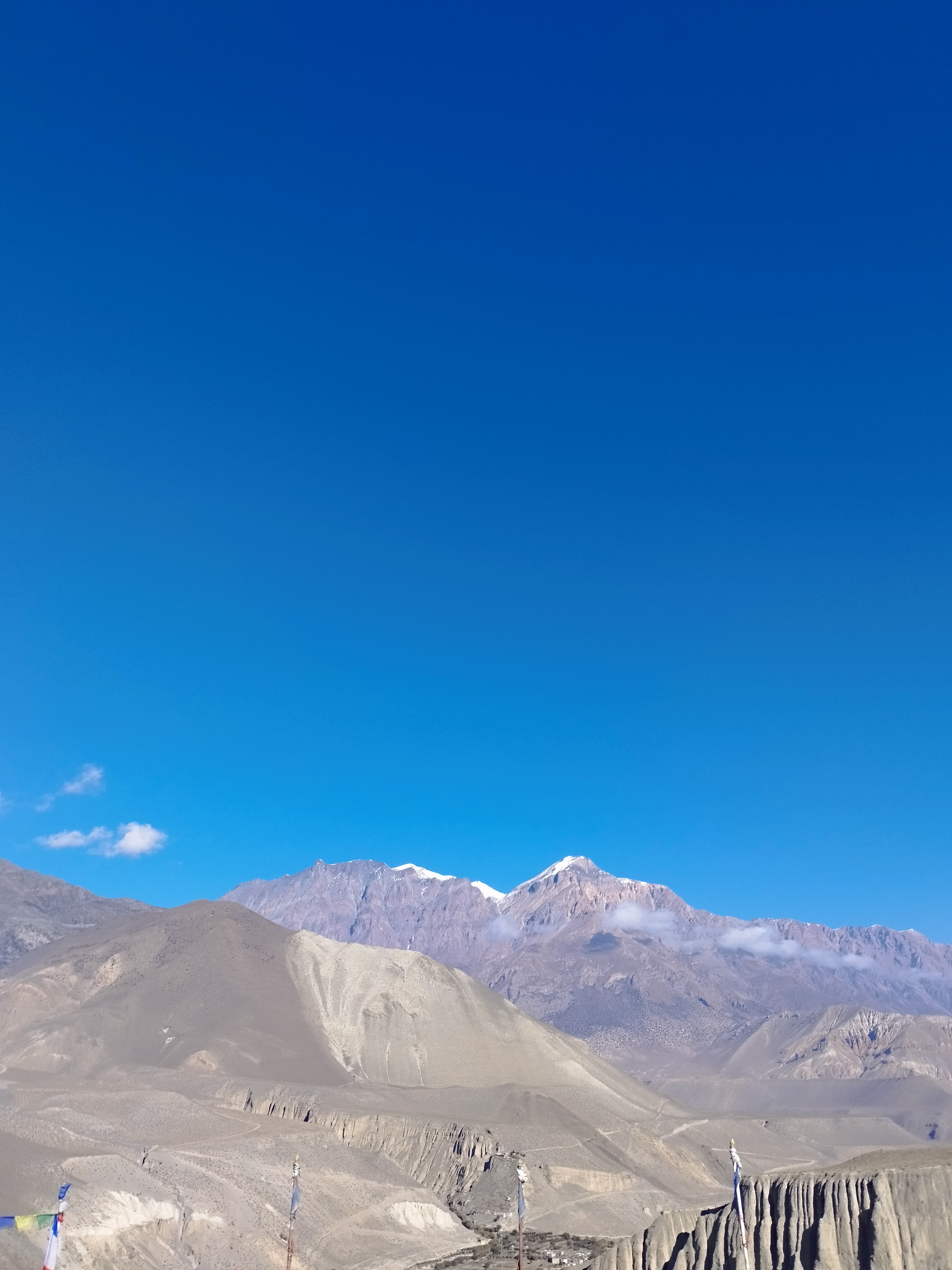 A landscape showcasing rugged mountains under a clear blue sky.