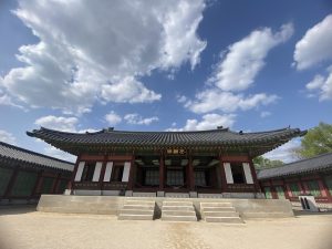 

A traditional Asian building with a curved roof, featuring intricate architectural details in green and red.
