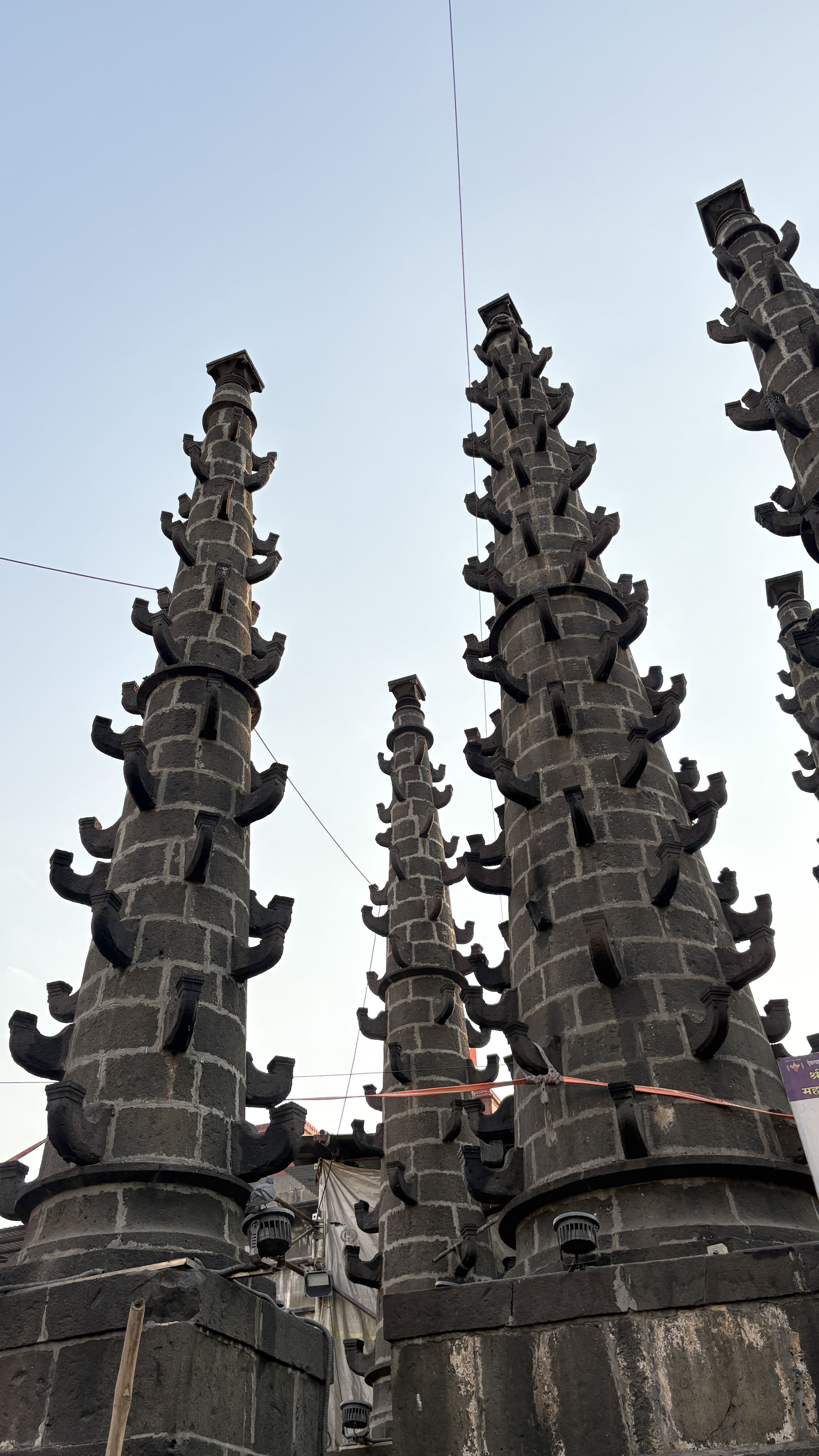Tall stone towers with intricate, staggered protrusions, set against a clear sky.
