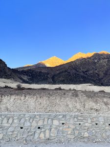 A panoramic view of rugged mountains under a clear blue sky.