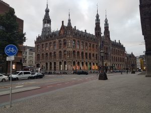 A large, ornate, historic building with intricate architectural details under a cloudy sky. 
