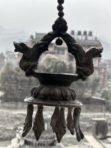 An ornate metal hanging lamp with dragon motifs and decorative tassels.