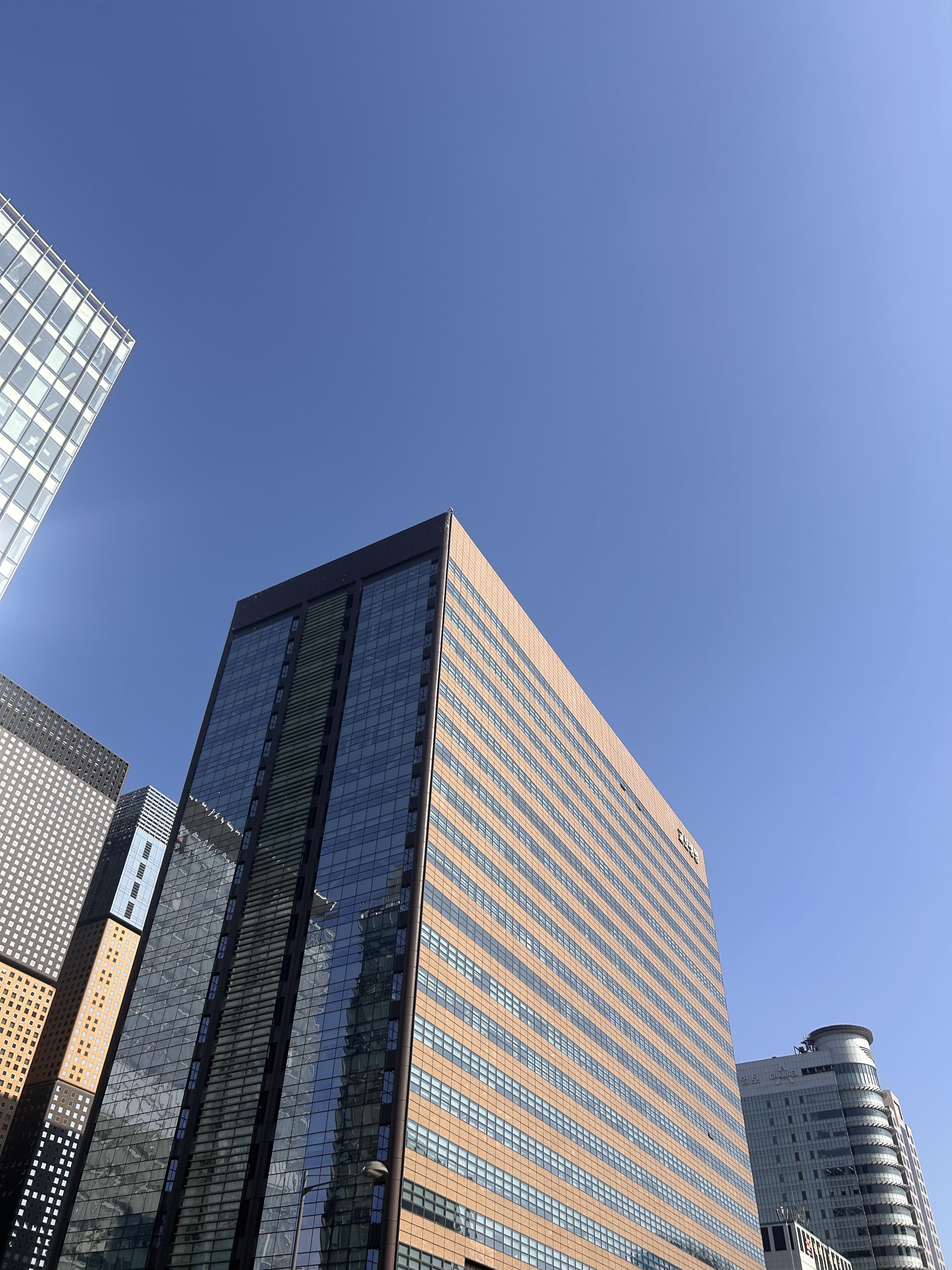 A modern urban landscape featuring tall buildings with glass facades