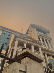 A large, multi-story building with neoclassical architectural elements including columns and a decorative facade.