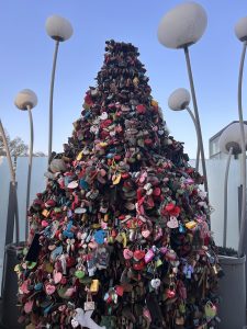 A large decorative structure resembling a Christmas tree made entirely of colorful padlocks of various sizes and shapes.