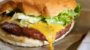 A close-up image of a hamburger featuring a sesame seed bun.