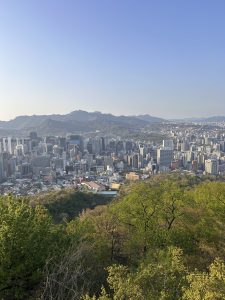 A panoramic view of a bustling cityscape nestled against a backdrop of mountains.