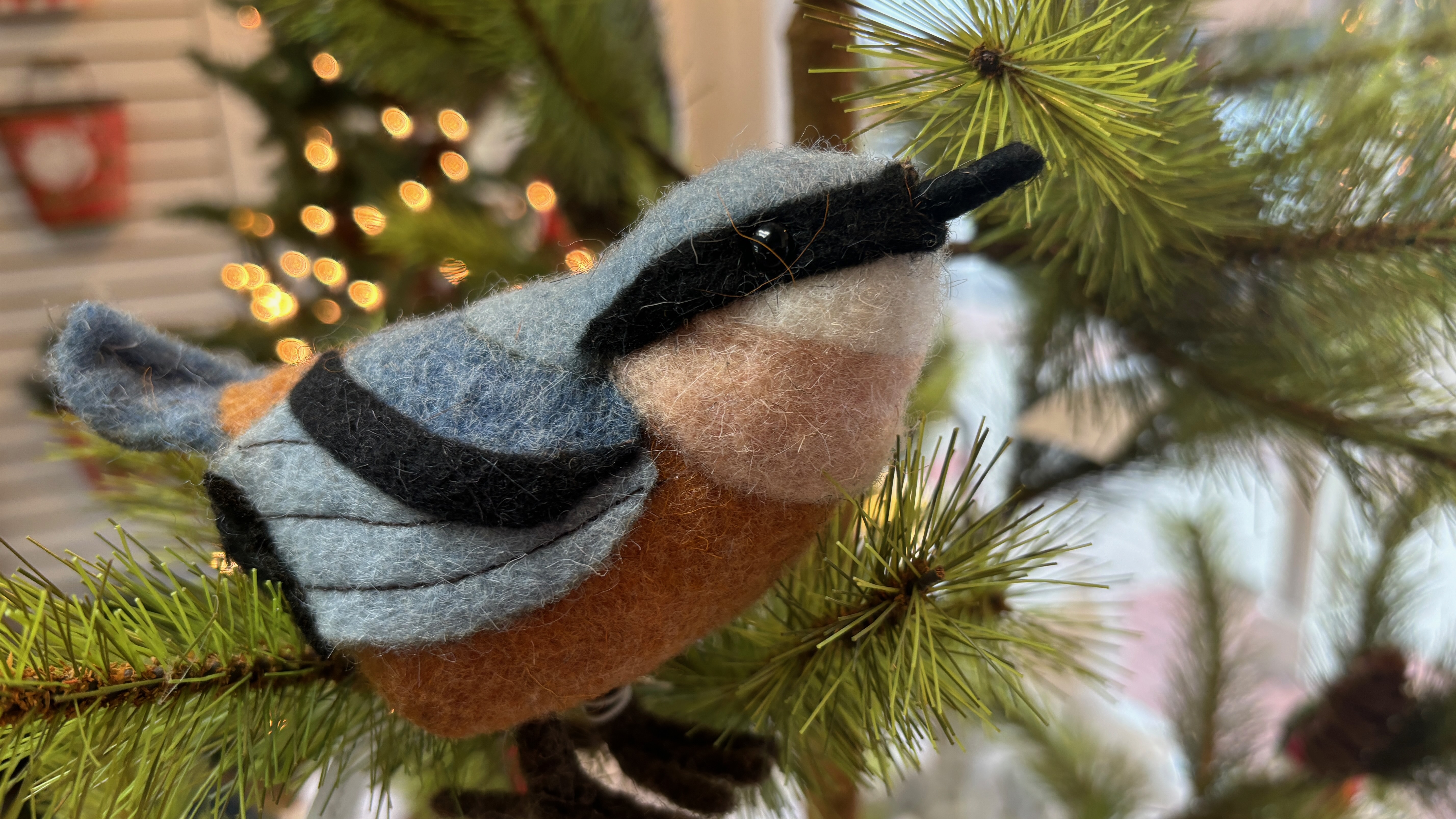 A Christmas tree ornament in the shape of a bird made of natural fibers.