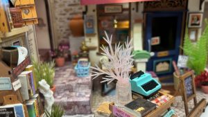 A room interior in miniature, with a clear plant and tiny type writer.