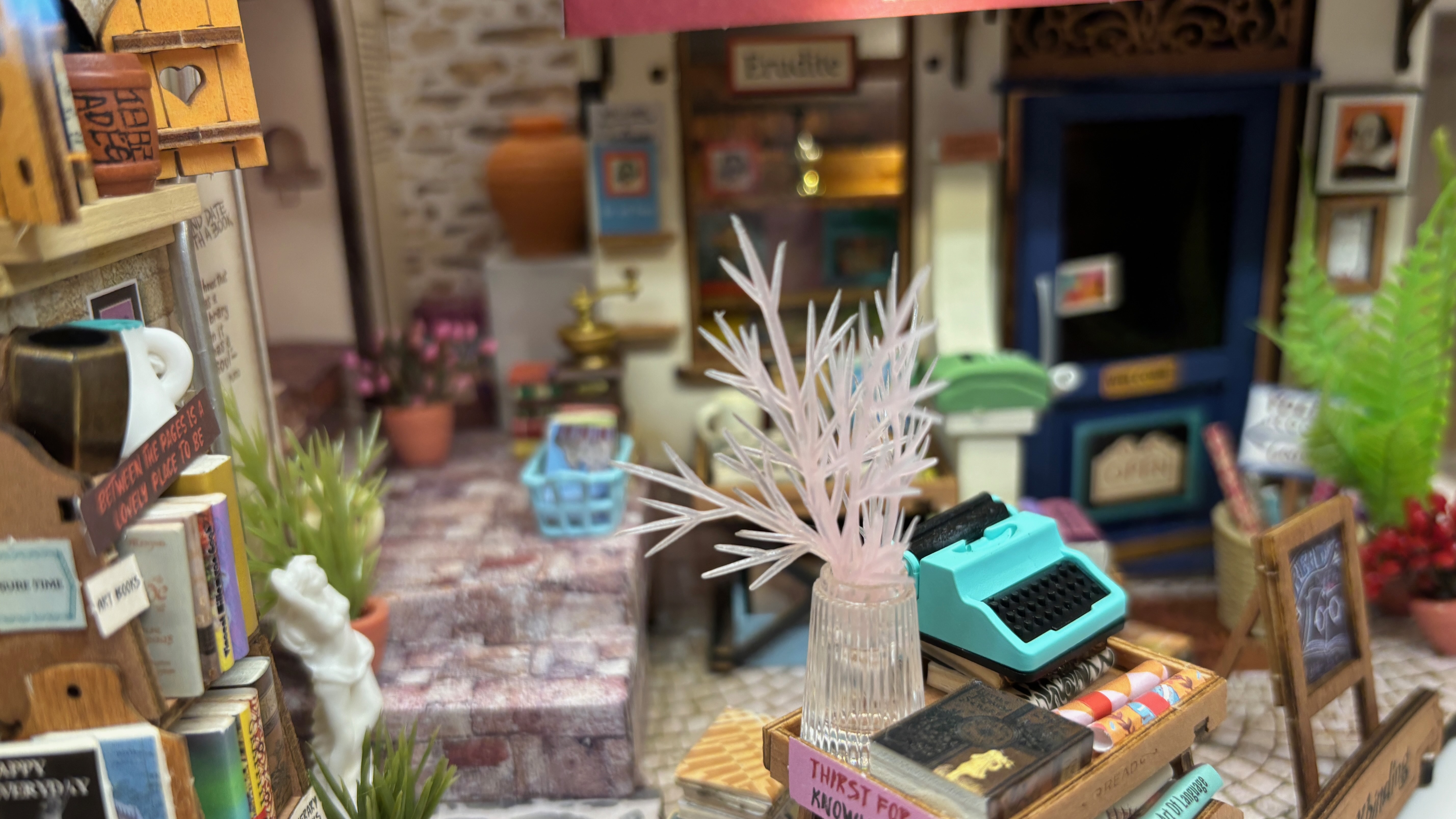 A room interior in miniature, with a clear plant and tiny type writer.