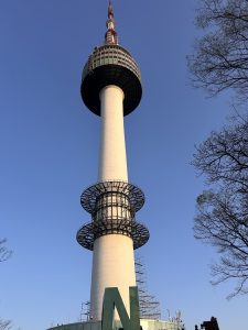 A tall N Seoul tower stands against a clear blue sky. 