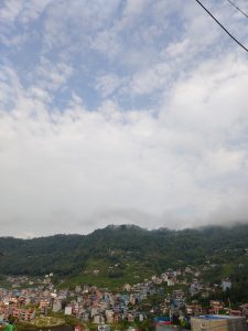 A scenic view of a hillside town with colorful buildings nestled among lush green slopes.