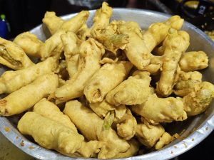 A bowl full of Mirchi (Chili) bajji, also known as Chili Pakoras. These are chili fritters, coated in a spiced batter and deep-fried to a golden brown, and captured from Thrissur, Kerala. 