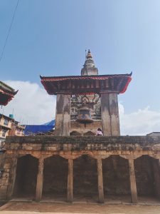 A traditional architectural structure featuring a large bell hanging beneath a roofed pavilion.
