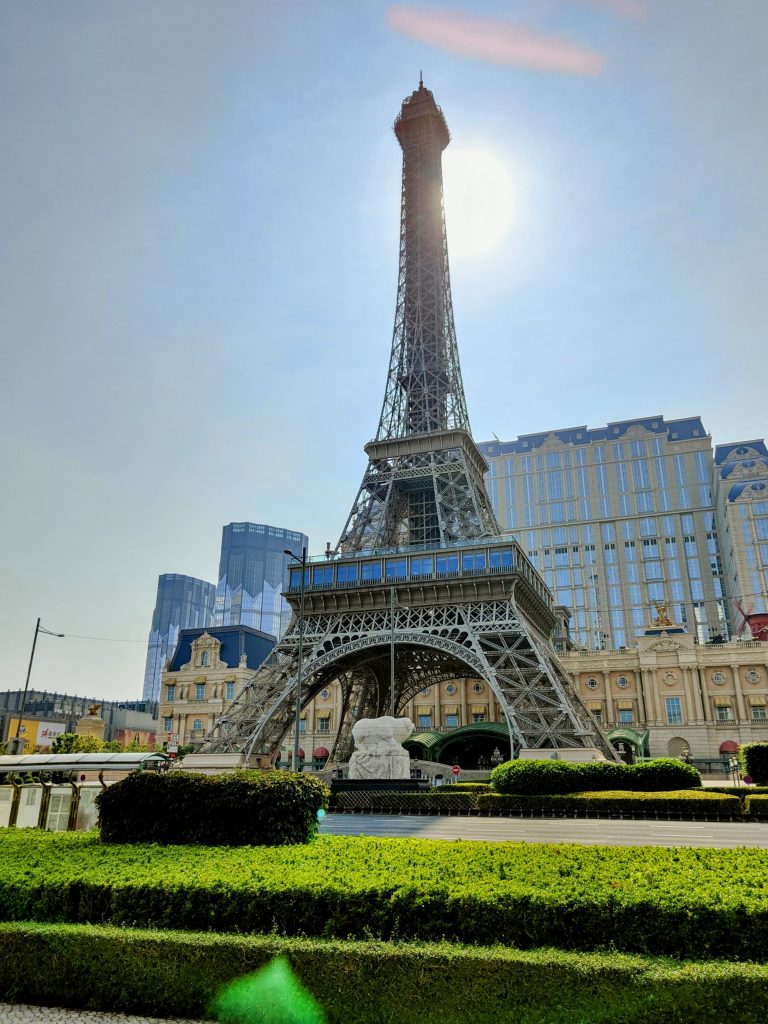 Sunset backlight silhouettes the Eiffel Tower replica at The Parisian Macao, highlighting its stunning architecture and elegant surroundings – Parisian charm in the heart of Macao.