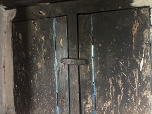 

A pair of old wooden windows, slightly ajar, showing signs of wear and tear with scratches and a rough texture.