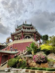 A colorful Asian-style pavilion with intricate roof details and decorative elements at the Taoist Temple in Cebu, Philippines, set against a cloudy sky.