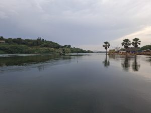A tranquil Nile river scene featuring calm waters reflecting the surrounding landscape.
