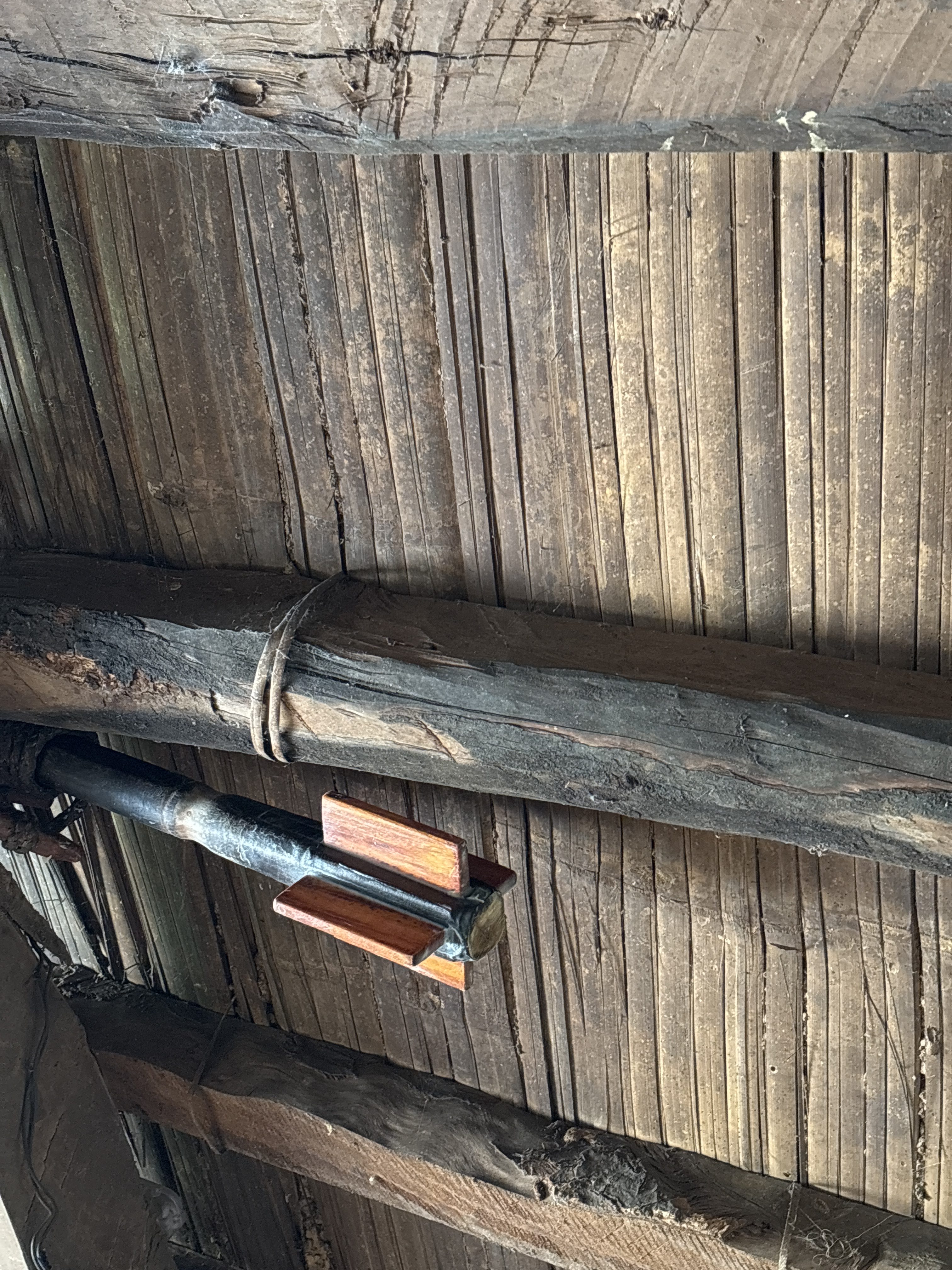 A wooden ceiling featuring exposed beams and planks.
