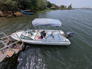 A small speedboat rests along the shores of the River Nile.
