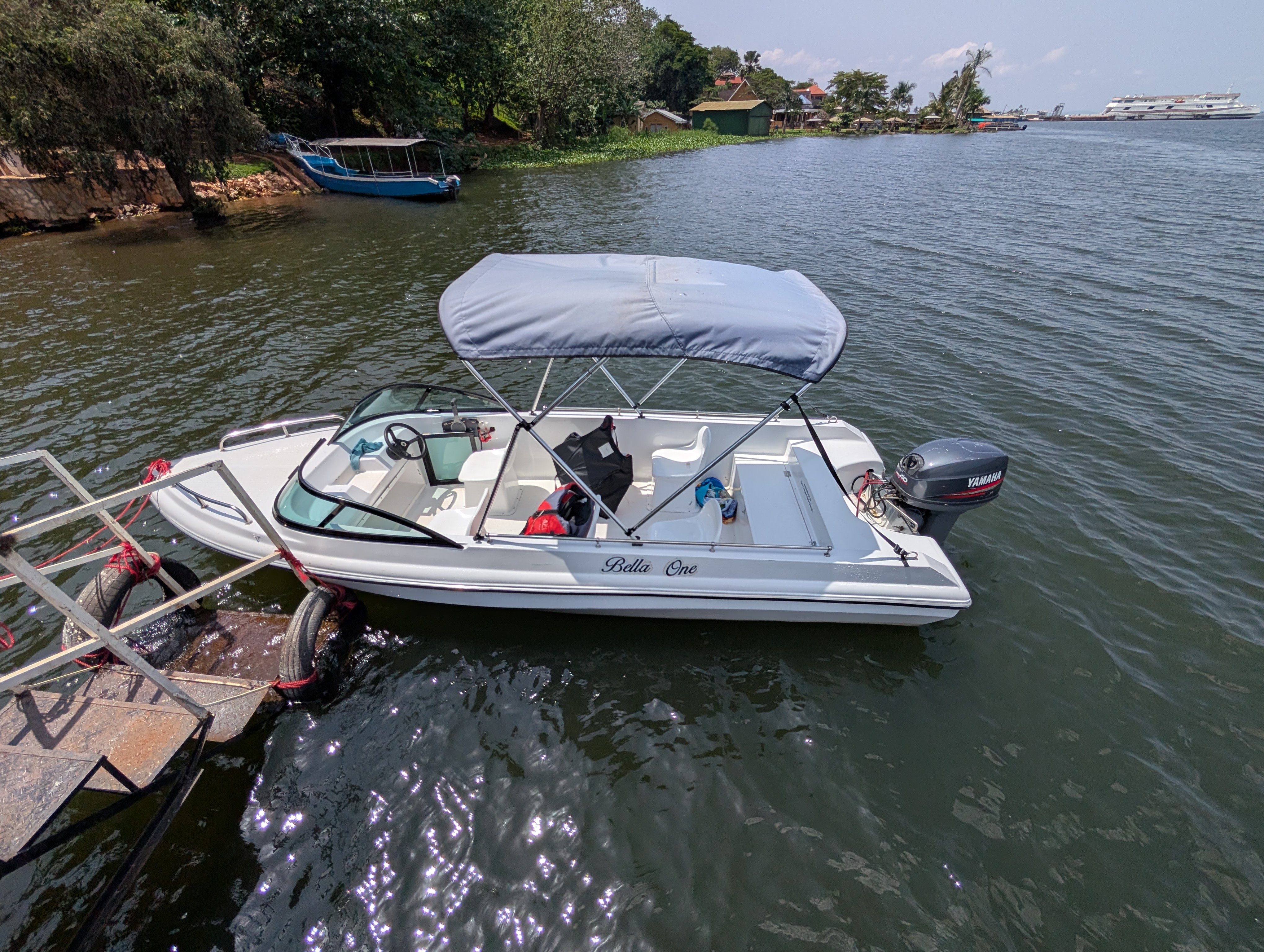 A small speedboat rests along the shores of the River Nile.