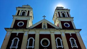 A view of a historic church with two prominent bell towers, each topped with a cross.