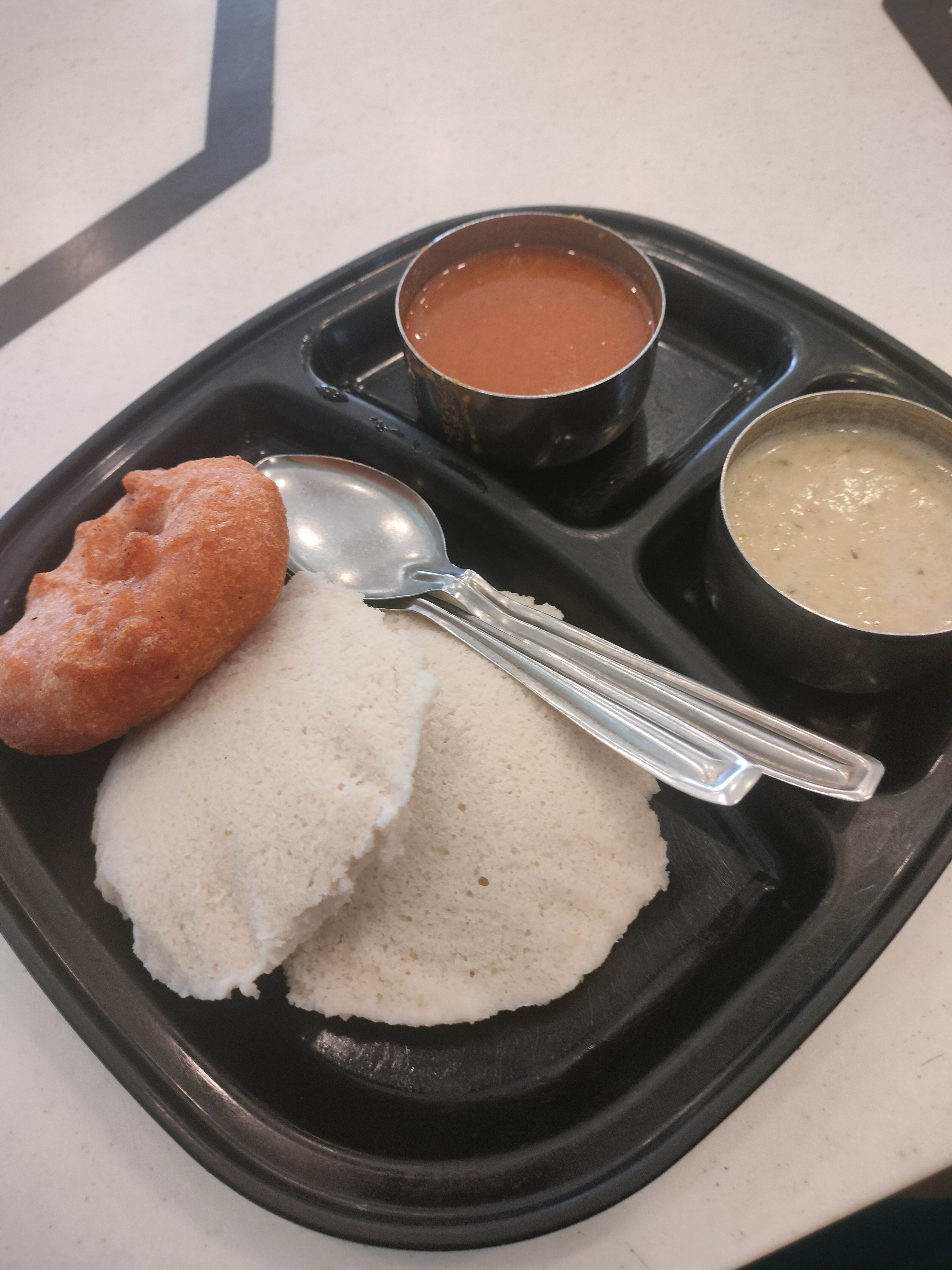 A South Indian breakfast dish, Idli is a steamed rice cake, and vada is a savory fried snack. Chutney and sambar are common side dishes served with South Indian meals.