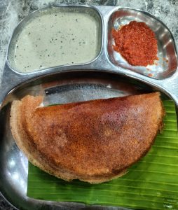 Mulbagal dosa is a crispy and golden-brown crepe, originating from Mulbagal, Karnataka. This dosa, served on a banana leaf with coconut chutney and spicy red chutney, has a thin, crispy exterior and a soft, fluffy interior.
