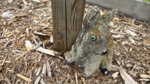 A deeply weather worn figurine of a fawn.