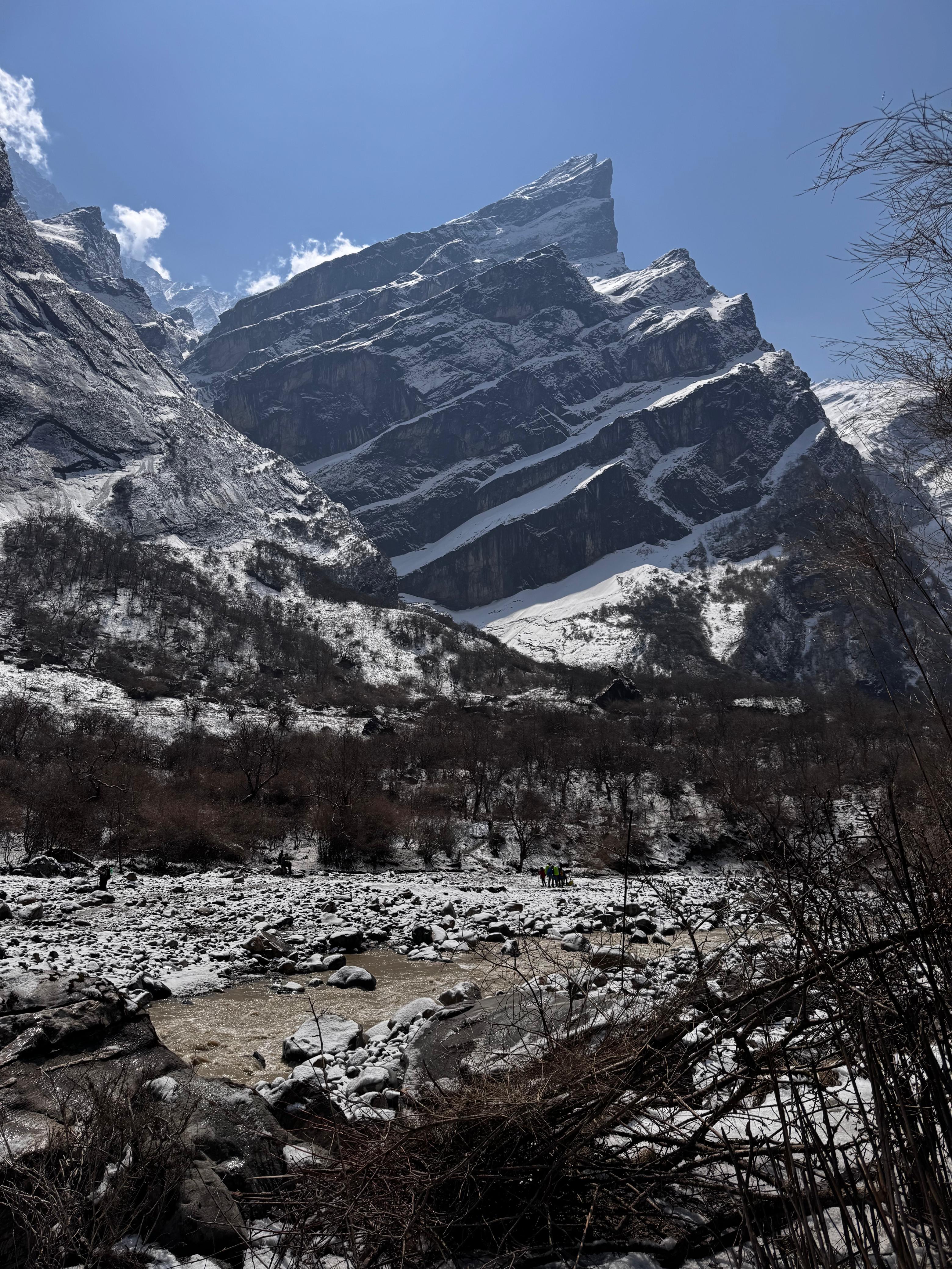 A snow-covered mountainous landscape under a clear blue sky.