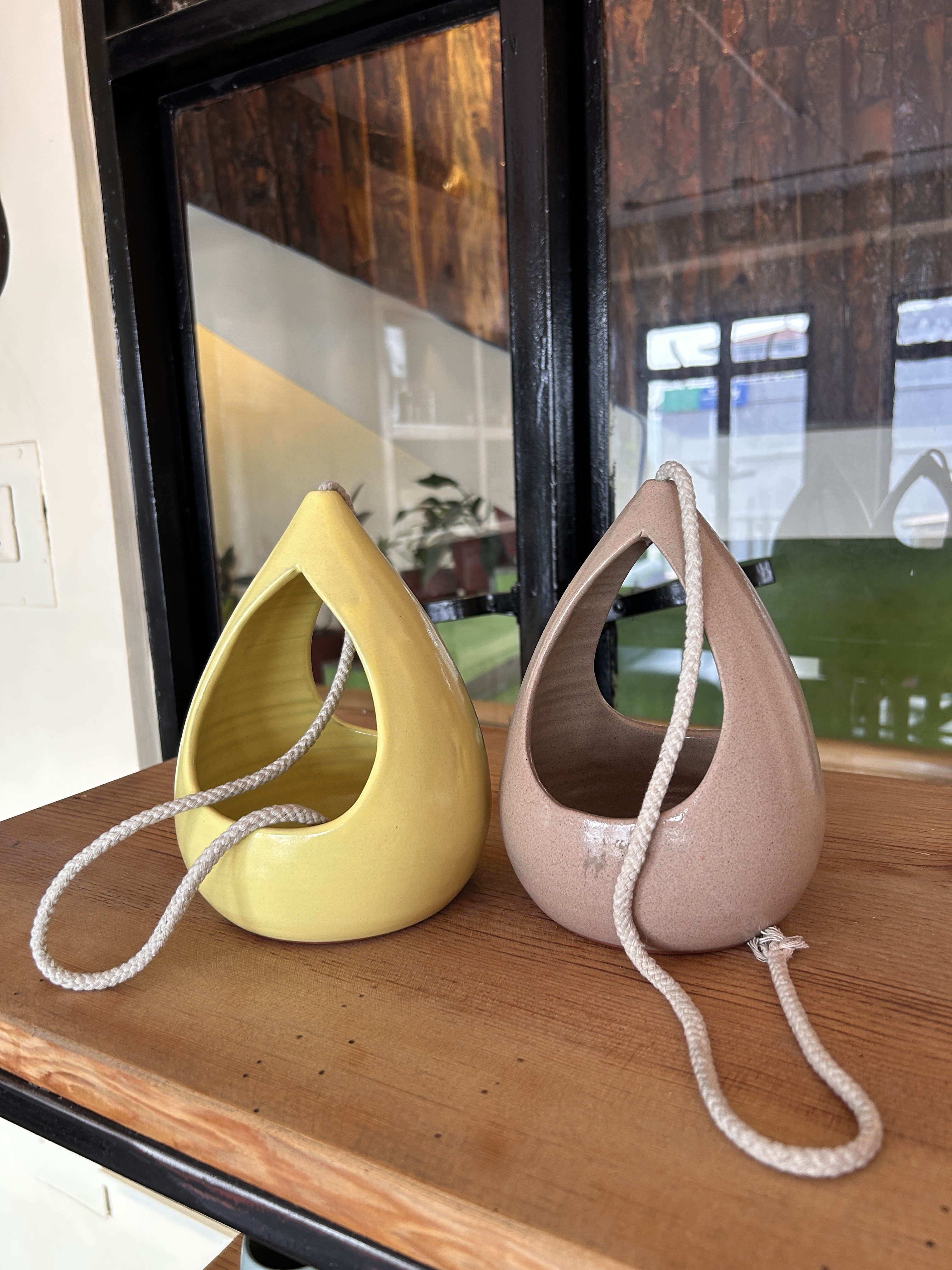 Two decorative ceramic vases are displayed on a wooden surface.