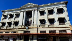 An old classic building featuring a prominent clock on its facade, showcasing exquisite architectural details and timeless grandeur.