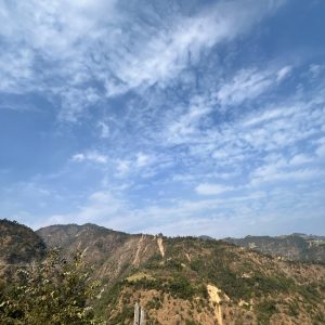 A scenic view of rolling hills under a blue sky with scattered clouds. 