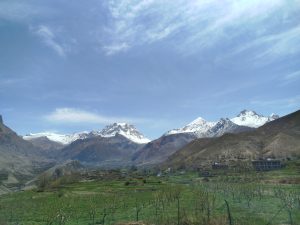 A scenic Mustang landscape with majestic snow-capped mountains under a clear blue sky.
